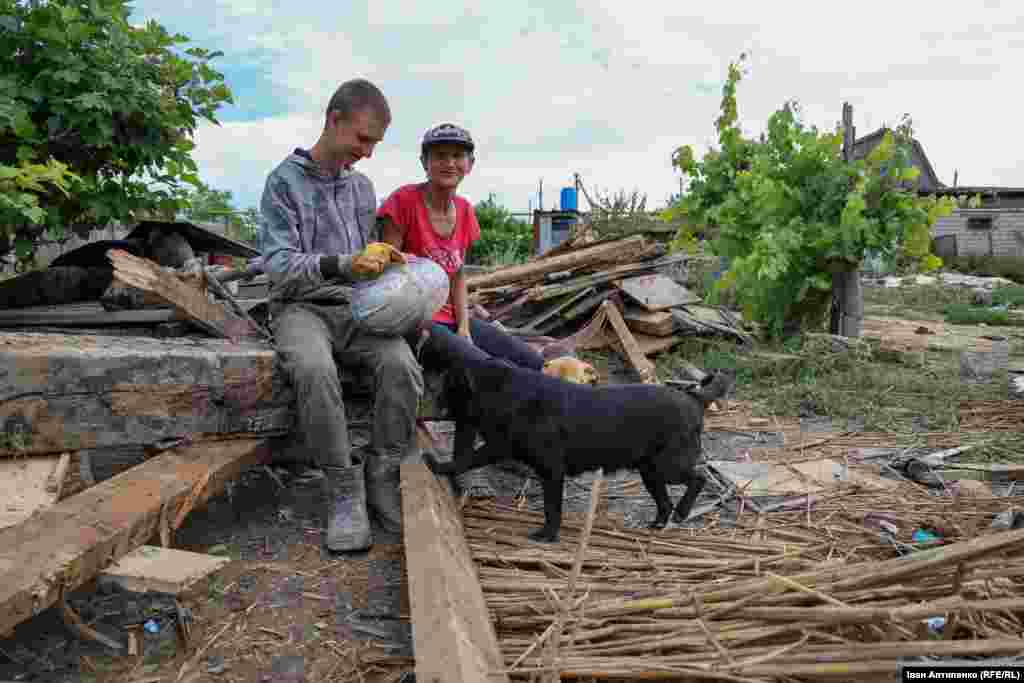 Альона і її син Євген (13 років) з селища Білозерка біля свого зруйнованого затопленням будинку. Вони попросили сусіда допомогти вигребти трактором залишки стін із подвір&rsquo;я. Наразі родина живе у кумів