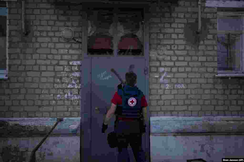 Волонтер Євген Кириченко заходить в житловий будинок, щоб забрати бажаючих евакуюватися. На стіні будинку видно літеру &laquo;Z&raquo; &ndash; символ російської армії у війні з Україною. На початку повномасштабного вторгнення російські війська захопили&nbsp;Куп&rsquo;янськ. У&nbsp;вересні 2022 року ЗСУ під час контрнаступу відвоювали це українське місто