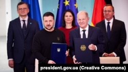Президент України Володимир Зеленський і канцлер Німеччини Олаф Шольц (праворуч) під час церемонії підписання Угоди про співробітництво у сфері безпеки та довгострокової підтримки між Україною та Німеччиною. Берлін, 16 лютого 2024 року