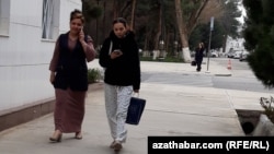 Türkmenistanyň köçeleriniň birinde mobil telefondan peýdalanyp barýan zenanlar (Illýustrasiýa suraty)