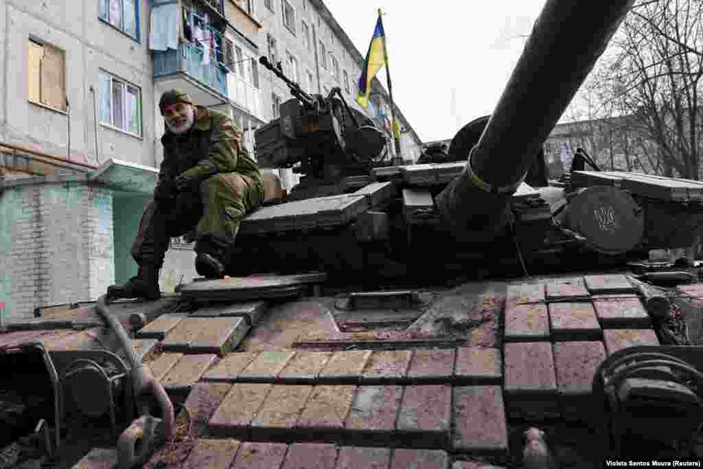 A Ukrainian soldier sits atop a tank outside battle-scarred apartments near Bakhmut.&nbsp; Located astride two major crossroads, the battle for &quot;Fortress Bakhmut&quot; continues despite Russian claims that it has captured the eastern city.