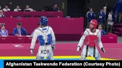 حکمت الله زهین ( سرخ پوش) در جریان یک مسابقه تکواندو با رقیب کوریایی خود در رقابت های آسیایی چین