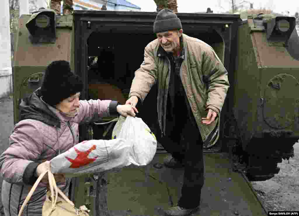 Civilians rescued from Bakhmut carry their personal belongings as they step out of a Ukrainian armored personnel carrier in Chasiv Yar. They will be transported further away from the war zone to an internally displaced persons (IDP) shelter in&nbsp;Kostyantynivka.