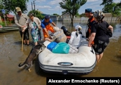 Евакуація людей з затопленої зони на надувному човні в Голій Пристані, червень 2023 року