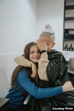 Юліна подруга Каріна підтримувала її під час обрізання волосся на благодійній вечірці Goodbye Hair.