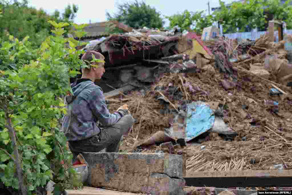 Євген дивиться на те, що залишилося від їхнього будинку