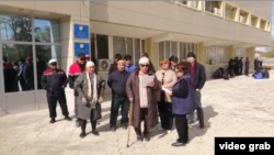 Жители Жанаозена зачитывают обращение к властям перед зданием акимата. Жанаозен, 4 апреля 2023 года