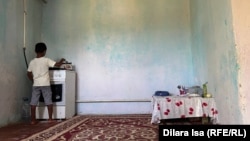 Әлеуметтік жағдайы төмен отбасындағы бала түскі асын ішу үшін отқа шай қойып жатыр. Шымкент, 2 тамыз, 2023 жыл (Азаттық архивіндегі фото)