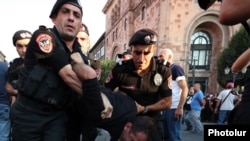 Police officers detain a protester near central government offices in Yerevan. August 8, 2023