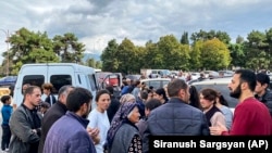 Nagorno-Karabakh - A local government worker, right in red, tries to calm residents down during shooting in the vicinity of Stepanakert, September 21, 2023.