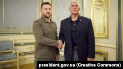 Ukrainian President Volodymyr Zelenskiy shakes hands with visiting former U.S. Vice President Mike Pence (right) in Kyiv on June 29.
