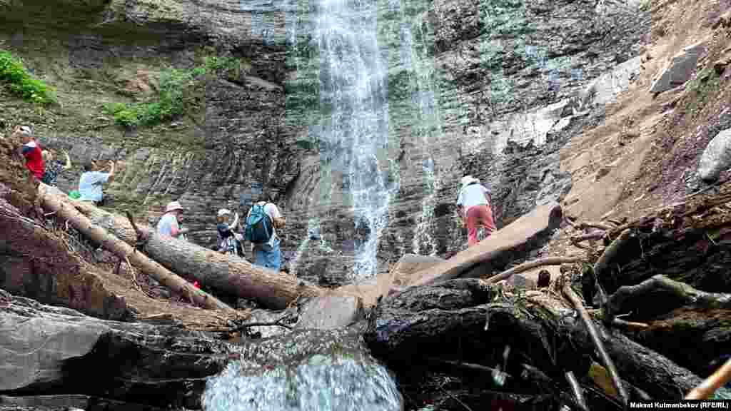 Үч чакырымдан ашык жөө басып, шаркыратмага жеткен туристтер сүрөткө түшүүгө ашыгышат.