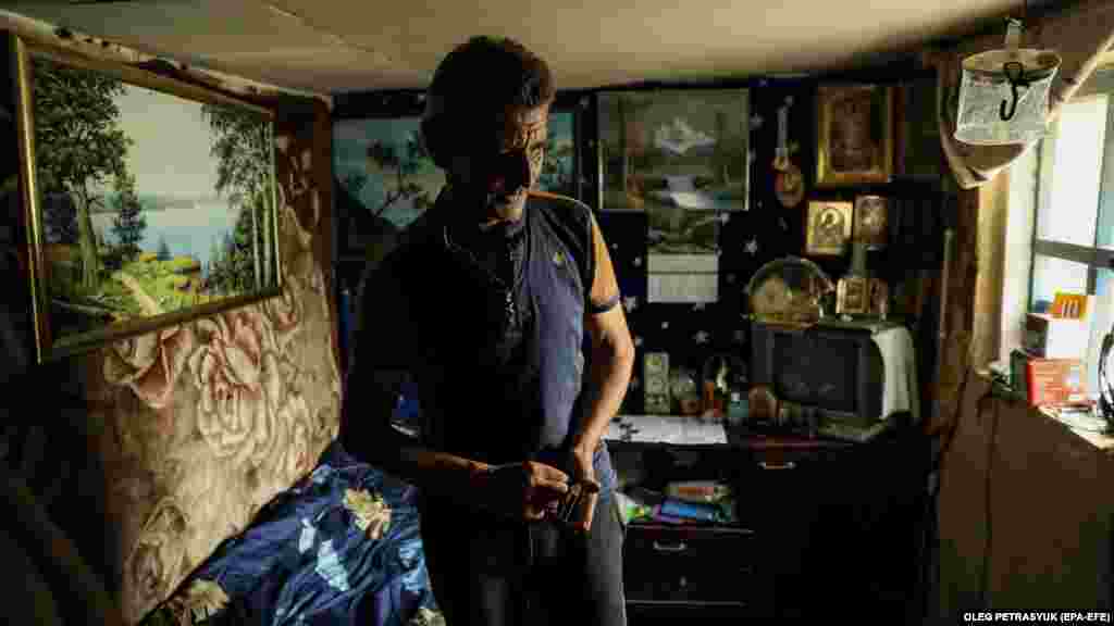 Микола стоїть в одній із частин свого будинку, придатних до життя. Йому сказали, що дадуть дрова та пелети для печей, але &laquo;це лише обіцянки&raquo;, вважає Микола