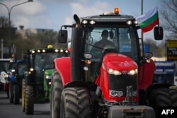 Farmers drive their tractors to block trucks crossing the Danube Bridge, which marks the border between Bulgaria and Romania, in a protest in late March against the duty-free import of grain coming from Ukraine into the EU.