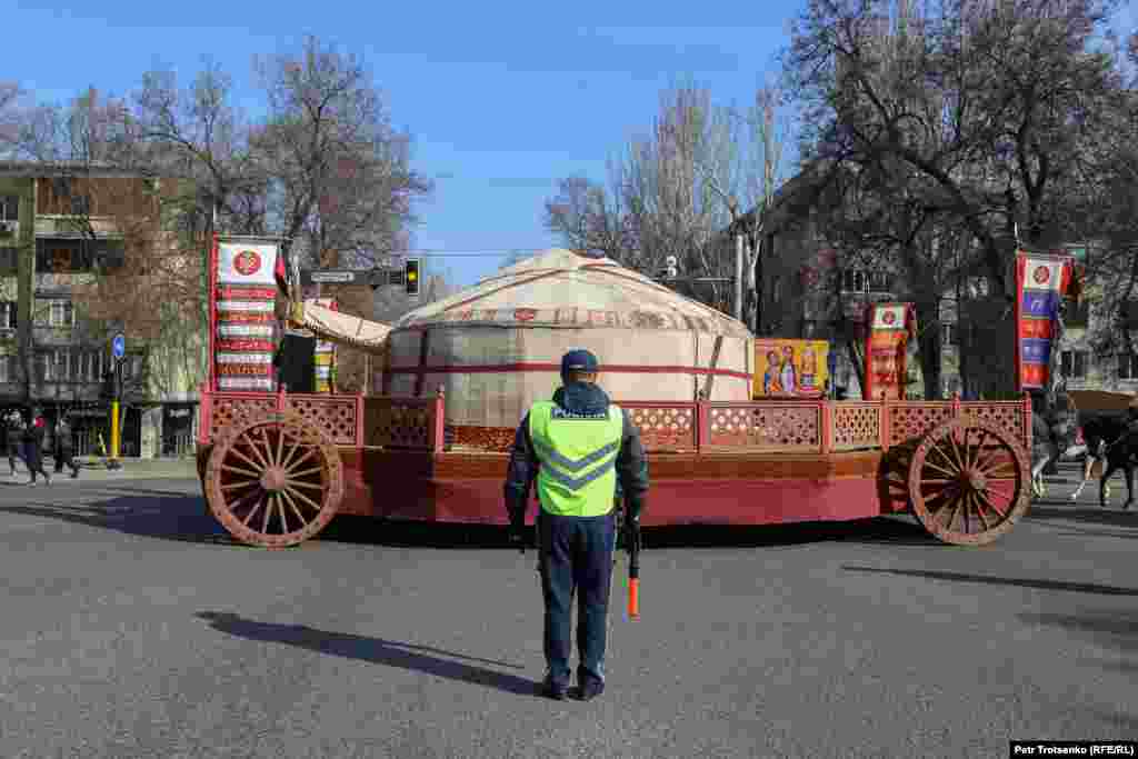 Утром 21 марта по Алматы прошло праздничное шествие в честь Наурыза. На фото&nbsp;&mdash; полицейский перекрывает движение на одном из центральных перекрёстков города, чтобы дать проехать огромной самоходной юрте, которая возглавляла праздничный парад&nbsp;