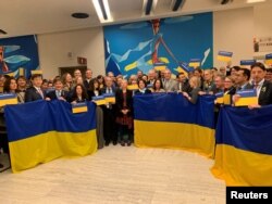 Орусиянын тышкы иштер министринин орун басары Рябков Женевада сүйлөгөн учурда бир катар өлкөлөрдүн делегаттары Украинанын желегин көтөрүп турушту.