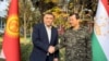 Kyrgyz security chief Kamchybek Tashiev (left) and his Tajik counterpart, Saimumin Yatimov, shake hands earlier this month. 