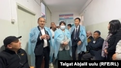 Саламаттык сактоо министри Алымкадыр Бейшеналиев жана билим берүү министри Сузактагы ооруканага барган учур. 