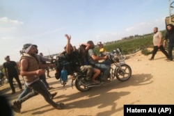 Палестинці везуть захоплену ізраїльтянку з кібуцу Кфар Азза у смугу Газа. 7 жовтня 2023 року