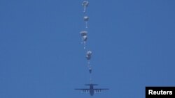 عکس از آرشیف - یک طیاره نظامی اردن کمک های بشری را ذریعه پاراشوت برای افراد ملکی که در نوار غزه با قحطی رو به رو اند پرتاب می کند. 