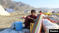 کودک یک خانواده که از پاکستان اخراج شده اند از اموال شان در منطقه تورخم مواظبت می کند