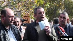 Armenia - A refugee from Karabakh shows his Armenian passport during a protest outside the Ministry of Labor and Social Affairs, Yerevan, November 6, 2023.