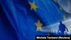 Европа Биримдигинин желеги жана анын фонунда басып бараткан киши. Иллюстрация