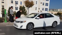 Hususy ulagynda kireý edýän sürüji bilen gürleşýän aşgabatly ýaşaýjylar (Illýustrasiýa suraty)