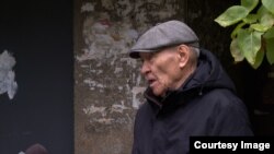 Гүлнара Ракишеванын батири деп көрсөтүлгөн үйдүн жанында жашаган Алматынын тургуну "Азаттыктын" кабарчысы менен сүйлөшүп турат.