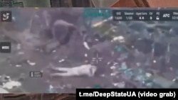 З бліндажа виходить другий український військовополонений, у цей час перший вже лежить на землі обличчям донизу