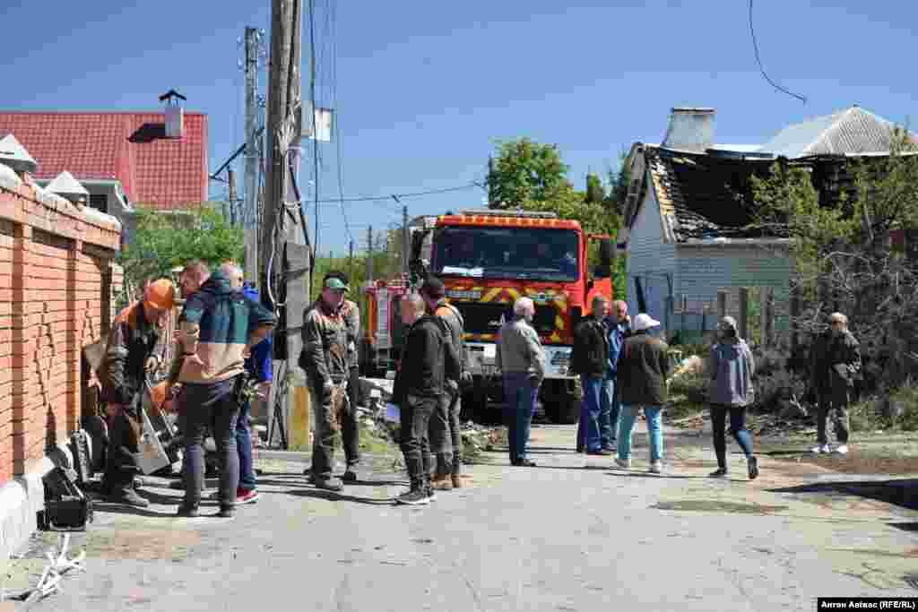 Рятувальнини і комунальники намагаються мініміізувати руйнівні наслідки влучення&nbsp; російської ракети С-400, 10 травня 2024 року