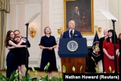 (çepde) Kurmaşewanyň adamsy Pawel Butorin, we olaryň iki gyzy – Bibi we Miriam hem prezident Baýdeniň geçiren metbugat ýygnagyna gatnaşdylar.