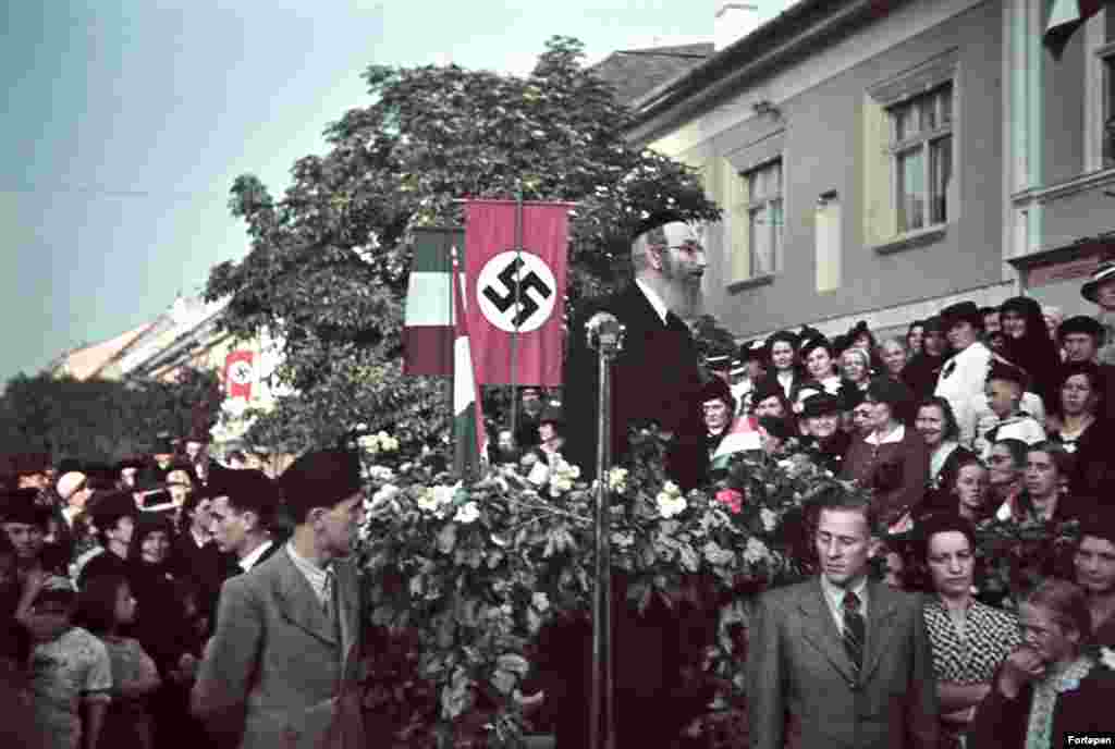 A rabbi speaks in front of a swastika in the Transylvanian town of Bistrita as Hungarian troops arrive in 1940. This striking image from Romania, along with the other photos in this gallery, are from the Fortepan photo archive. The collection of mostly amateur photos captures life in Central Europe through the 20th century. &nbsp; &nbsp;