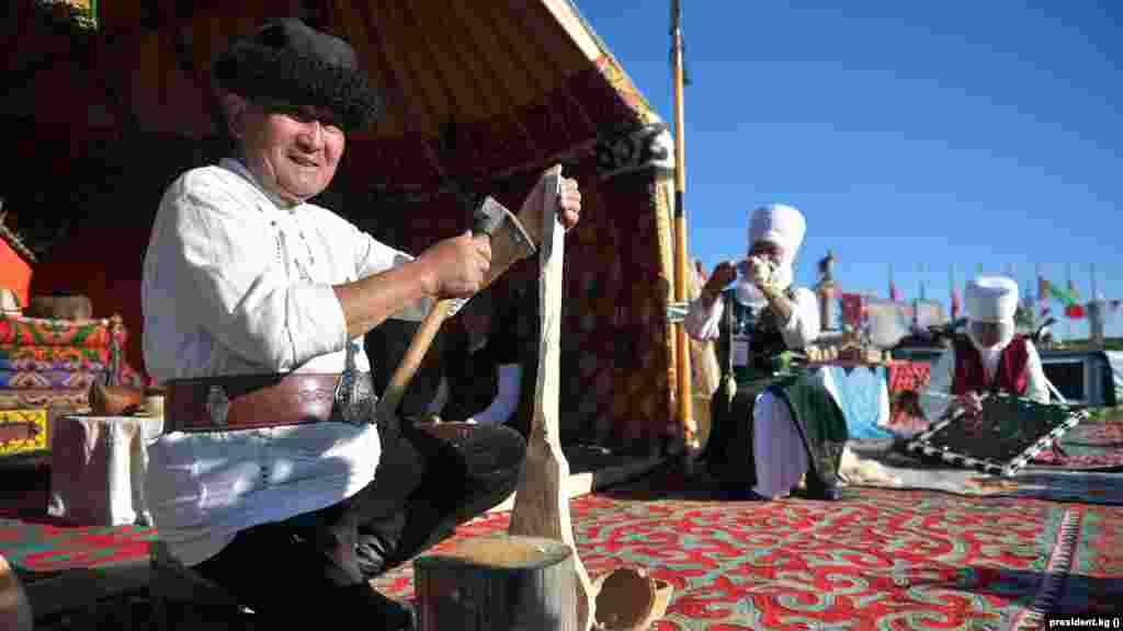 Комуз чаап жаткан уста.