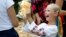A Ukrainian refugee girl receives a Teddy bear during an event for refugee children in Bucharest, Romania, on August 24.