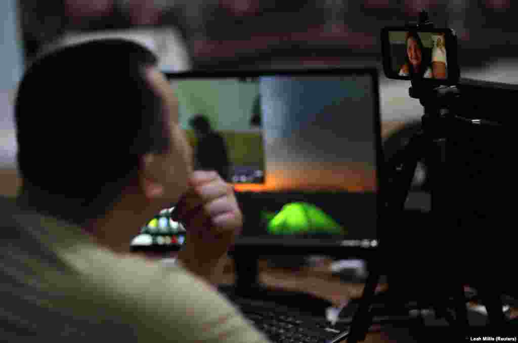 Роман Качанов, керівник пожежної частини, розмовляє зі своєю дочкою Віолеттою та дружиною Мариною через відеозв&#39;язок. Його рідні перебувають у Німеччині, поки він залишається у своїй пожежній частині в Харкові, 3 липня 2022 року