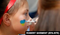 Девочка, вынужденная бежать от войны, в Румынии, накануне празднования Дня независимости Украины, август 2022 года