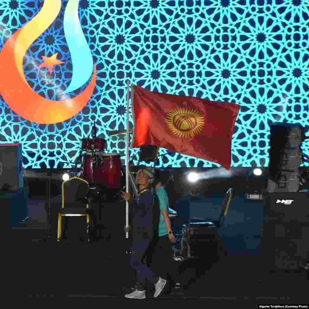 Оюндардын расмий жабылуу аземинде Кыргызстандын желегин кикбокс боюнча Ислам оюндарынын күмүш медалынын ээси Адилет Улан уулу көтөрүп баратат.