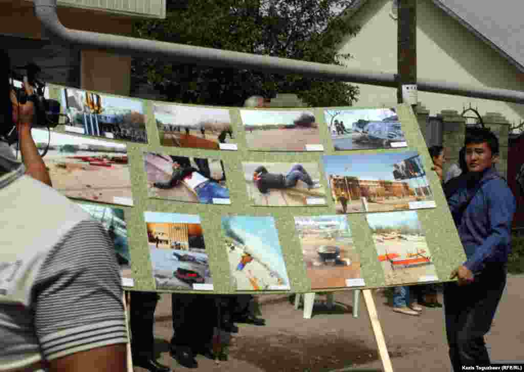 Организаторы фотовыставки переносят щиты с фотографиями. Село Алатау Алматинской области, 15 мая 2012 года. 