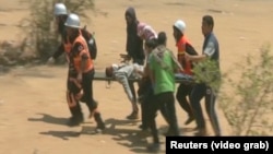 Эпизод противоборства между палестинцами и израильтянами: палестинцы несут раненого. 14 мая 2018