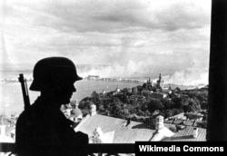 Немецкий часовой в крепости Цитадель на правом берегу Днепра. Панорама Киева с горящим мостом. 19 сентября 1941 года. Bundesarchiv.