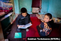 Абдимажит иниси Абдикарим менен китеп окуп жатышат.