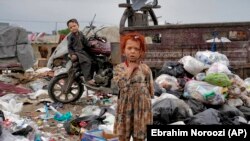 عکس آرشیف: دو تن از اطفال درکابل دیده می‌شوند که سرگرم جستجو در انبار ذباله ها اند. 