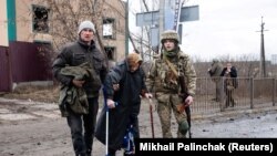 Украиналык аскер Киев облусунун Ирпин шаарында улгайган аялды эвакуациялоого көмөктөшүүдө