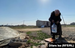 Пенсионерка Калайзада Рустемова набирает воду в пластиковую тару