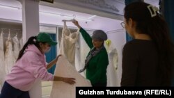 Нурила айым товарды Кытайдын Гуанчжоу шаарынан алып келет. Үлпөт көйнөктү кардарга көрсөтүп жатат.