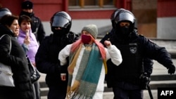 Police officers detain a woman during a protest against Russian military action in Ukraine in central Moscow on March 13.