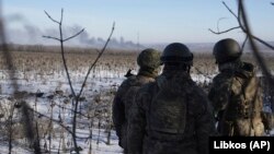 Ukrainian soldiers watch as smoke billows during heavy fighting in Soledar in the Donetsk region on January 11. 