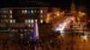 People walk past the Christmas tree on Sofiyska Square in Kyiv on December 19.