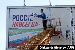 Комунальники прибирають залишки російських білбордів після звільнення Херсону, листопад 2022 року